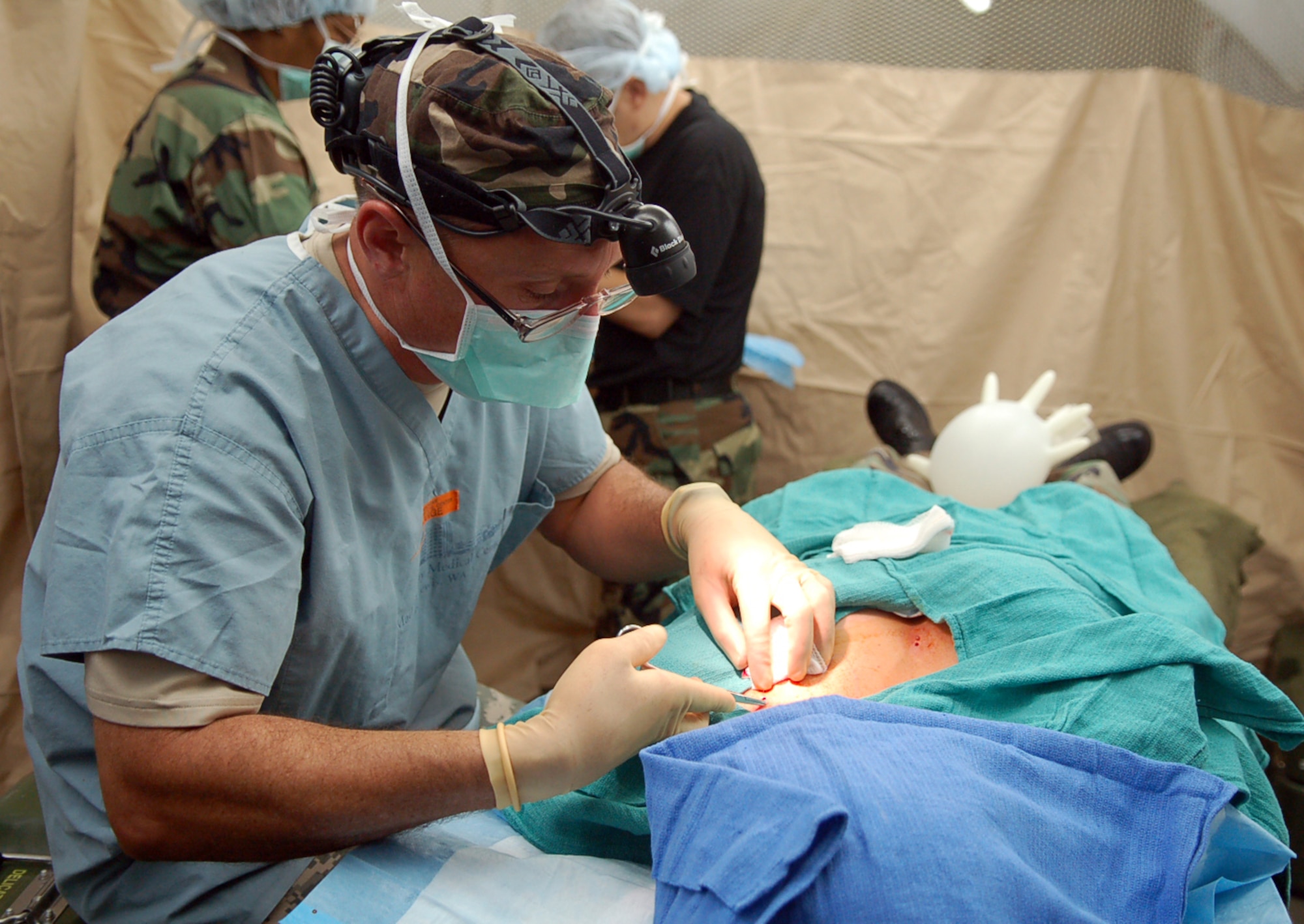 Army Lt. Col. (Dr.) Robert Rush, Joint Task Force-Bravo Medical Element Mobile Surgical Team commander, performs a skin lesion removal in the MST operating room.  The team set up the mobile operating room in an empty field here at night to practice setting up in limited visibility.  (U.S. Air Force photo by Staff Sgt. Austin May)