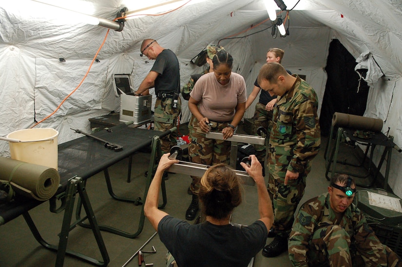 Members of the Joint Task Force-Bravo Medical Element work together to set up medical equipment inside a Mobile Surgical Team tent in an empty field here Oct. 18.  The team set up the mobile operating room at night to practice setting up in limited visibility.  (U.S. Air Force photo by Staff Sgt. Austin May)