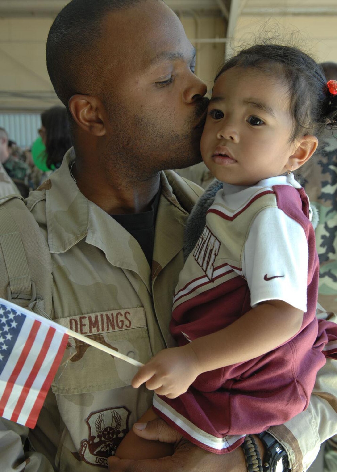 Tech Sgt. Kenyatta Demings, kisses the forhead of his 19 month old daughter Myka, after returning to home from a deployment to Afghanistan along with other Airmen, Oct. 23. Sergeant Demings is a munitions inspector assigned to the 355th Equipment Maintenance Squadron. (U.S. Air Force photo by Senior Airman Christina D. Kinsey)