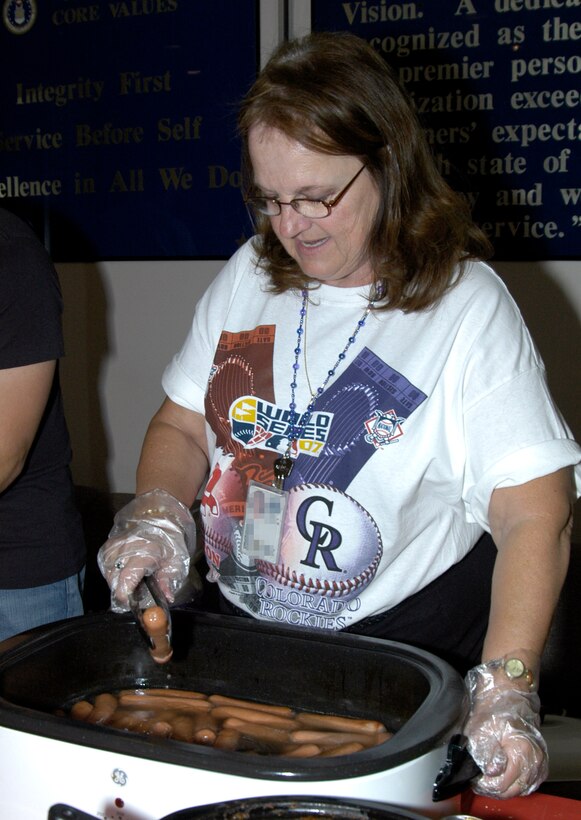 Karen Willett at the Air Reserve Personnel Center in Denver, Colo., serves hot dogs during the Booster Club's hot dog sale on Wednesday to celebrate the Colorado Rockies' World Series appearance. (U.S. Air Force photo/Mike Molina)