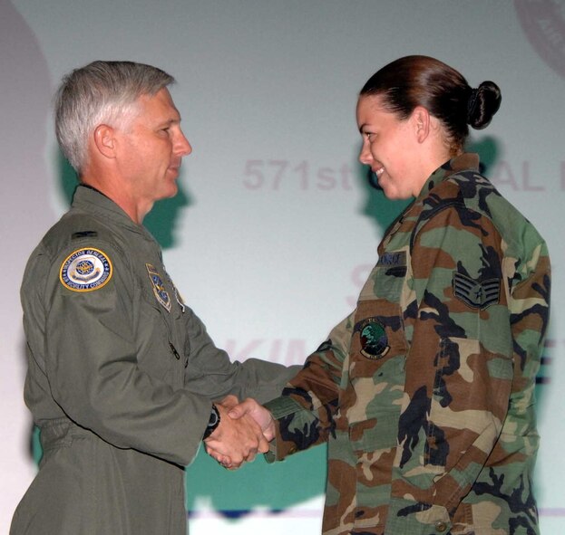 Col. Mike Callis, Air Mobility Command deputy inspector general, presents Staff Sgt. Kimberly Overturf, 571st Global Mobility Squadron, with an IG coin for outstanding performance during the 615th Contingency Response Wing's Operational Readiness Inspection. The ORI was designed to test the 615th CRW's ability to open up and handover an operational airbase. The wing earned an overall "Excellent" rating. (U.S. Air Force photo/Nan Wylie)