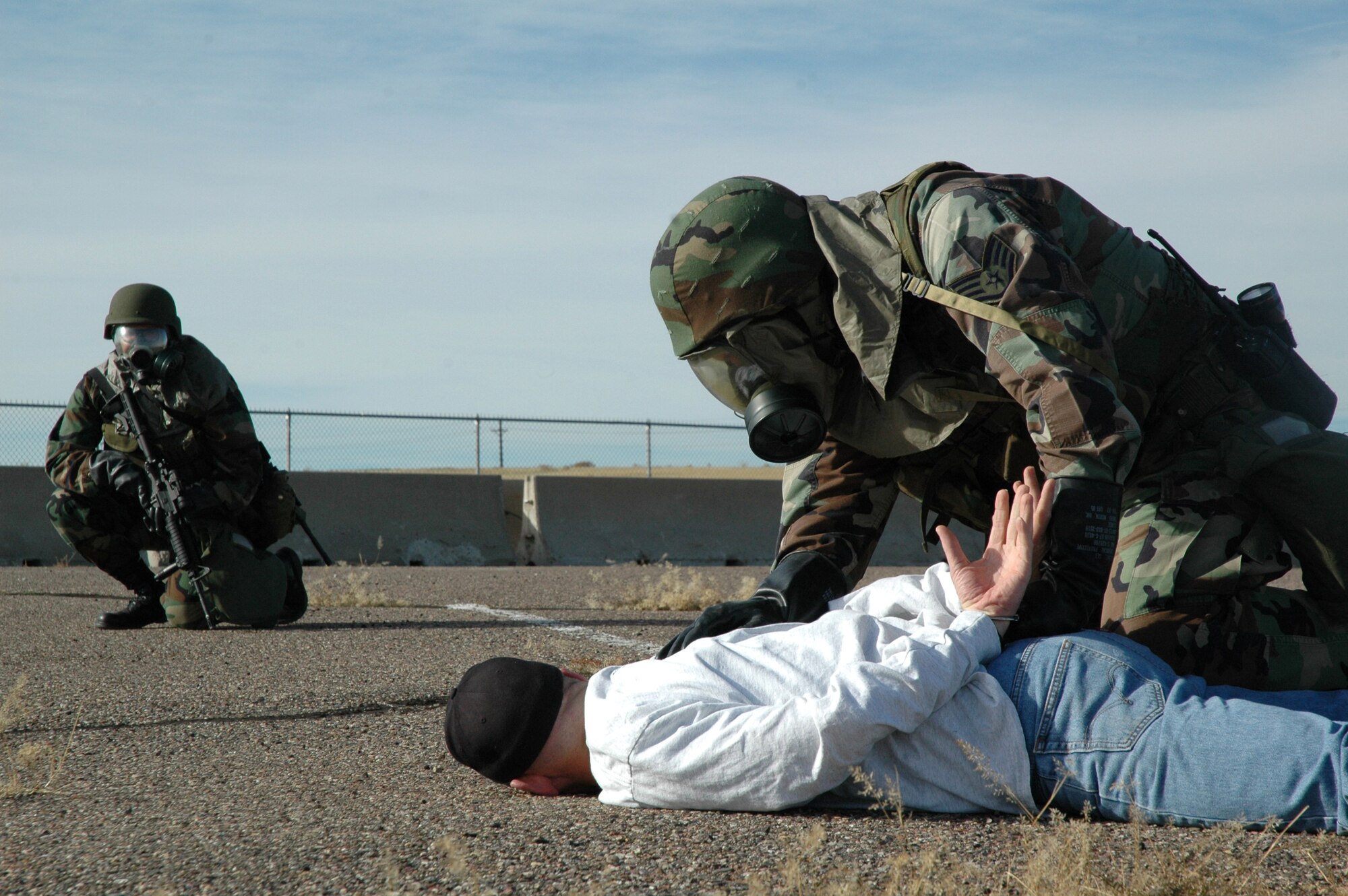 Staff Sgt. Thomas Green, 341st Security Forces Group, interrogates a mock terrorist pilot while 1st Lt. Ryan Williams, 341st SFG, stands guard in the background during an exercise scenario at Malmstrom Oct. 23. During the three-day exercise, Malmstrom tested its initial implementation of the Air Force Incident Management Program. The program trains emergency response personnel and specialized teams from the base to speak a standardized language with their civilian counterparts when responding to any incident. (U.S. Air Force photo/Staff Sgt. Marcus McDonald)