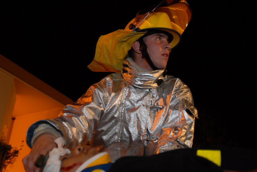 Airman Aaron Stehouwer, 18th Civil Engineering Squadron, reports the status of "injured" Airman Basic Lemar Mayberry, 18th Component Maintence Squadron, to fellow fire fighters at Kadena Air Base, Japan, Oct. 24, 2007. The Airmen are supporting training missions based on real-world scenarios as part of Local Operational Readiness Exercise Beverly High 08-1. (U.S. Air Force photo/Senior Airman Darnell T. Cannady)