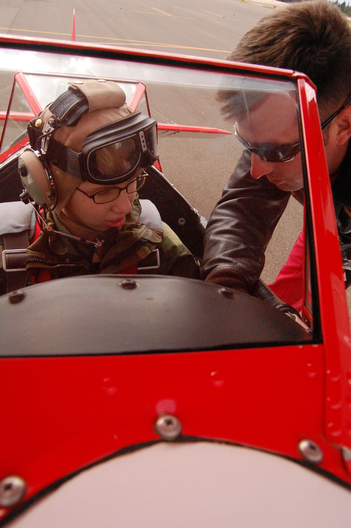 LAUGHLIN AIR FORCE BASE, Texas -- Airman Lindy Leggett, 47th Aero medical Dental Squadron, is instructed on the details of the Stearman Biplane by Matt Losaker, Red Baron Squadron Aerial Demonstration team, before experiencing her first ride with the Red Baron Pizza Squadron October 22. (U.S. Air Force photo by Airman Sara Csurilla) 