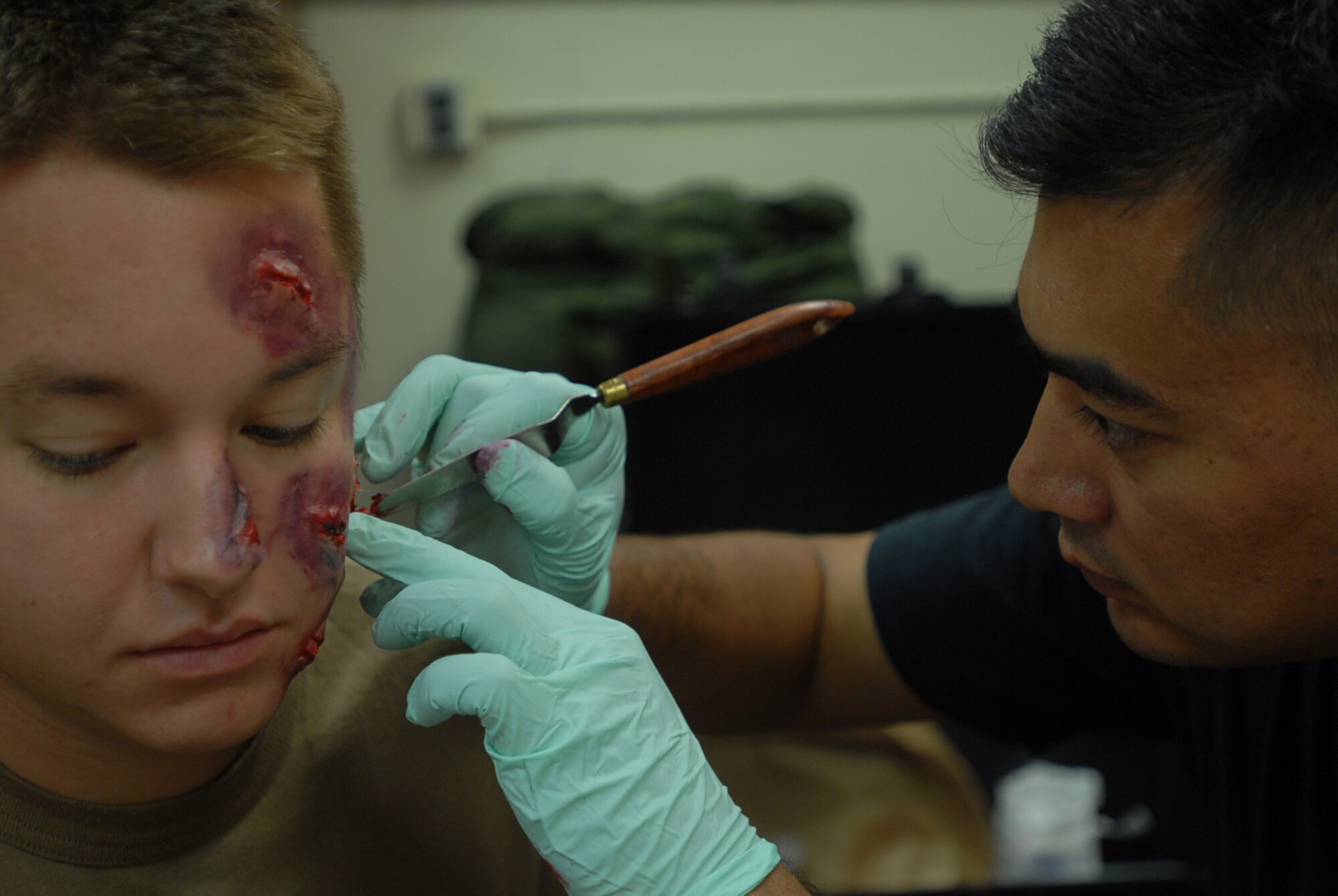 Tech. Sgt. Jay McLaren, 18th Dental Squadron, applies moualge to the head of Senior Airman James Wells, 909th Aircraft Maintence Unit, to simulate a wound during an exercise scenario at Kadena Air Base, Japan, Oct. 24, 2007.  Moulaged "victims" provide more realism to exercise scenarios. The Airmen are supporting training missions based on real-world scenarios as part of Local Operational Readiness Exercise Beverly High 08-1. (U.S. Air Force photo/Senior Airman Darnell T. Cannady) 