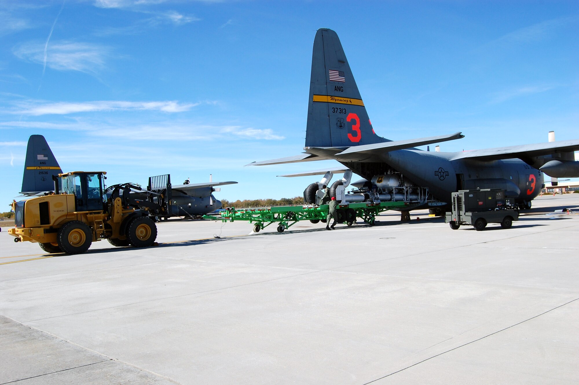Airmen from the Wyoming Air National Guard load the Modular Airborne Fire Fighting System onto a Wyoming Air National Guard C-130 Hercules Oct. 23 in Cheyenne, Wyo. The C-130 is being deployed to California to assist with firefighting efforts. Fires have ravaged Southern California forcing more than 500,000 people from their homes as the president has declared a federal emergency for seven counties in the state. The orange number on the tail identifies the plane as one of the units using the Modular Airborne Fire Fighting System to battle the blaze. (U.S. Army photo) 
