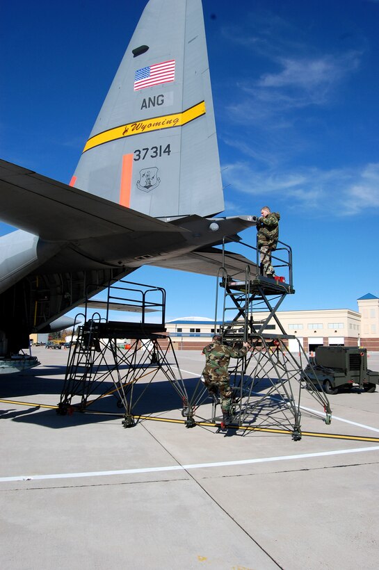 Wyoming Air National Guard maintainers prepare a C-130 Hercules for firefighting missions Oct. 23 in Cheyenne, Wyo. Fires have ravaged Southern California forcing more than 500,000 people from their homes as the president has declared a federal emergency for seven counties in the state. The orange number on the tail identifies the plane as one of the units using the Modular Airborne Fire Fighting System to battle the blaze. (U.S. Army photo)
