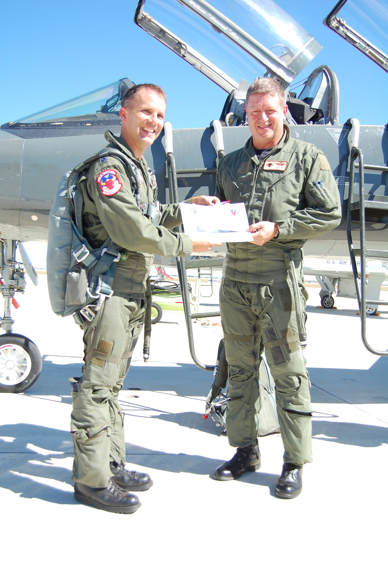 LAUGHLIN AIR FORCE BASE, Texas – Vice wing commander Col. Laro Clark (right) receives a certificate documenting his 2,000th T-38 flying hour from Lt. Col. Dean Lee who commands the 87th Flying Training Squadron's Red Bulls.  The 87th is responsible for conducting the final phase of specialized undergraduate pilot training for students who will continue on in the fighter/bomber track.  In 2007, Laughlin graduated 346 of the world's best trained pilots.  Colonel Clark adds this personal flying milestone to many others including service on the East Coast F-15 Aerial Demonstration Team, rating as a Euro-NATO Joint Jet Pilot and 220 combat hours in the F-15. He will deploy in January 2008 in support of the Global War on Terror. (U.S. Air Force Photo/Airman Sara Csurilla)