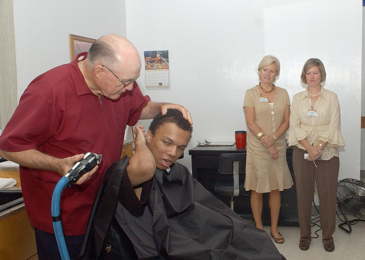 During the behind the scenes tour of basic military training at Lackland AFB, Texas, on Oct. 17, spouses of Air Education and Training Command commanders and command chiefs witnessed the initial hair cuts of new trainees at Clipper Cuts. The spouses had the opportunity to participate in tours of numerous BMT activities, including an M-16 trainer weapon and combat skills training demonstration, clothing issue orientation and field training orientation. (USAF photo by Alan Boedeker)                               
