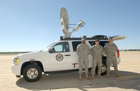From left, Army Staff Sgt. Roderick Hood, and Department of the Army civilians Joshua Wood and Mike Geffendall, all from U. S. Army North Command, proudly wait at Lackland AFB, Texas, Oct. 23, 2007, to load their Emergency Response Vehicle for a flight to help with the California fires. (USAF photo by Alan Boedeker)