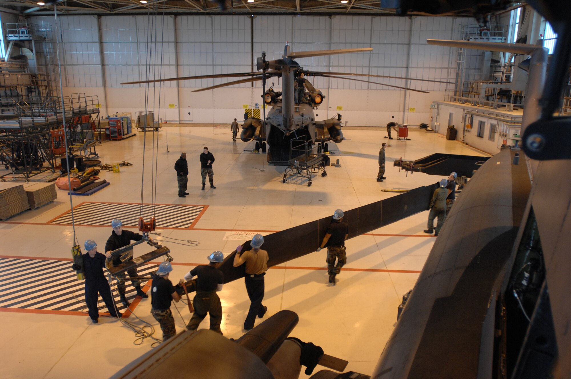 Crew chiefs and aircraft specialists in the 352nd Maintenance Squadron, Helicopter Maintenance Unit, remove rotor blades from one of the five MH-53M Pave Low IV Helicopters assigned to the 21st Special Operations Squadron, RAF Mildenhall, England, Oct. 02, 2007. Once the tear down process is complete, it usually takes an average two days; the helicopters will be transported to the Aerospace Maintenance and Regeneration Group in Tucson, Ariz., commonly known as the 'Boneyard.' All Pave Low helicopters in the Air Force inventory are due to be grounded by October 2008. (U.S. Air Force photo by Tech. Sgt. Tracy L. DeMarco)

