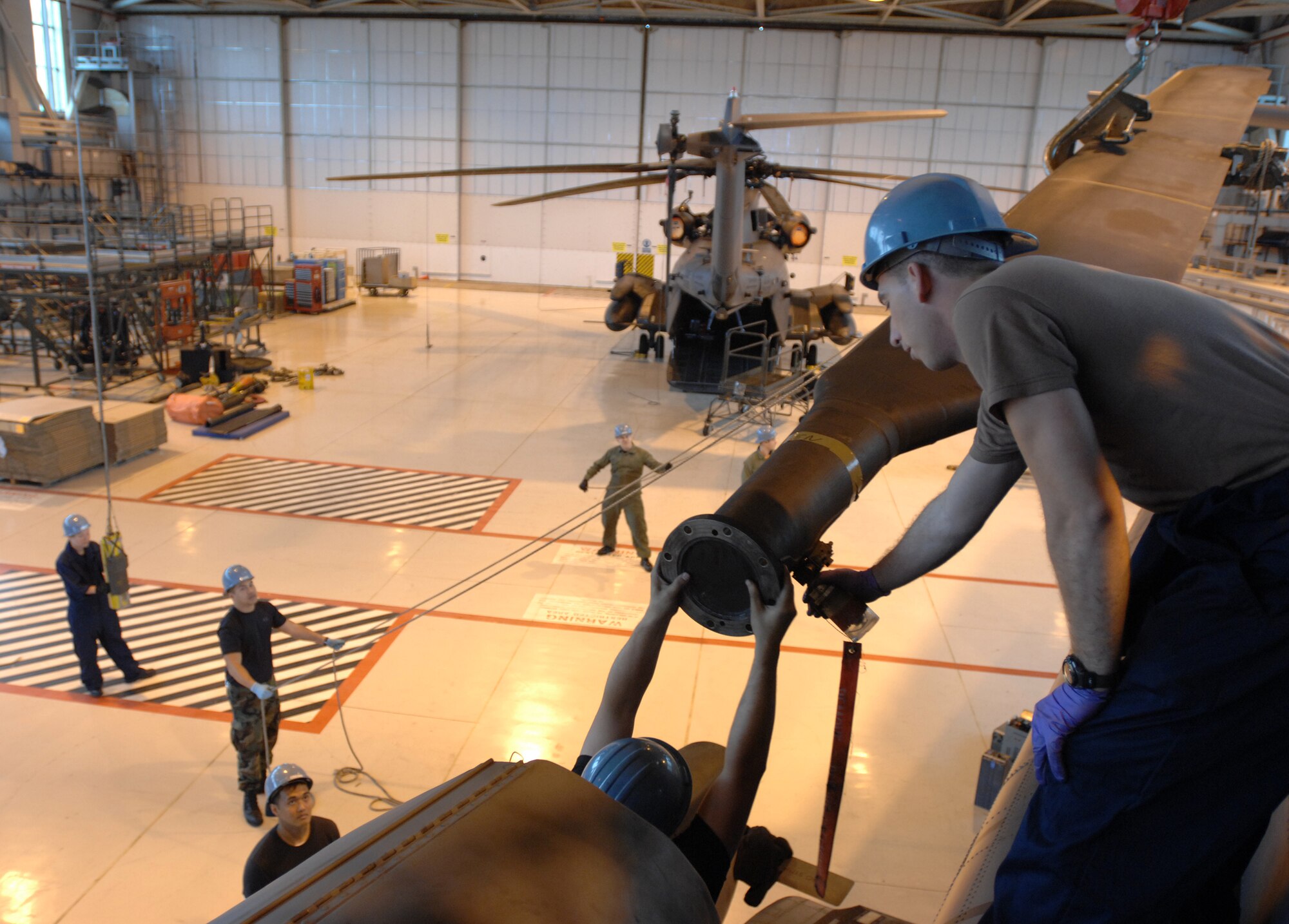 Staff Sgt. Justin Rich, a crew chief from the 352nd Maintenance Squadron, Helicopter Maintenance Unit, guides the last rotor blade away from MH-53M Pave Low IV tail number 95784 during the dismantling process to prepare the aircraft for storage at the Aerospace Maintenance and Regeneration Group in Tucson, Ariz., commonly known as the 'Boneyard,' Oct. 02, 2007, RAF Mildenhall, England.  Each rotor blade weighs 350 pounds and is lowered to the ground using an overhead hoist. All Pave Low helicopters in the Air Force inventory are due to be grounded by October 2008. (U.S. Air Force Photo by Tech. Sgt. Tracy L. DeMarco)

