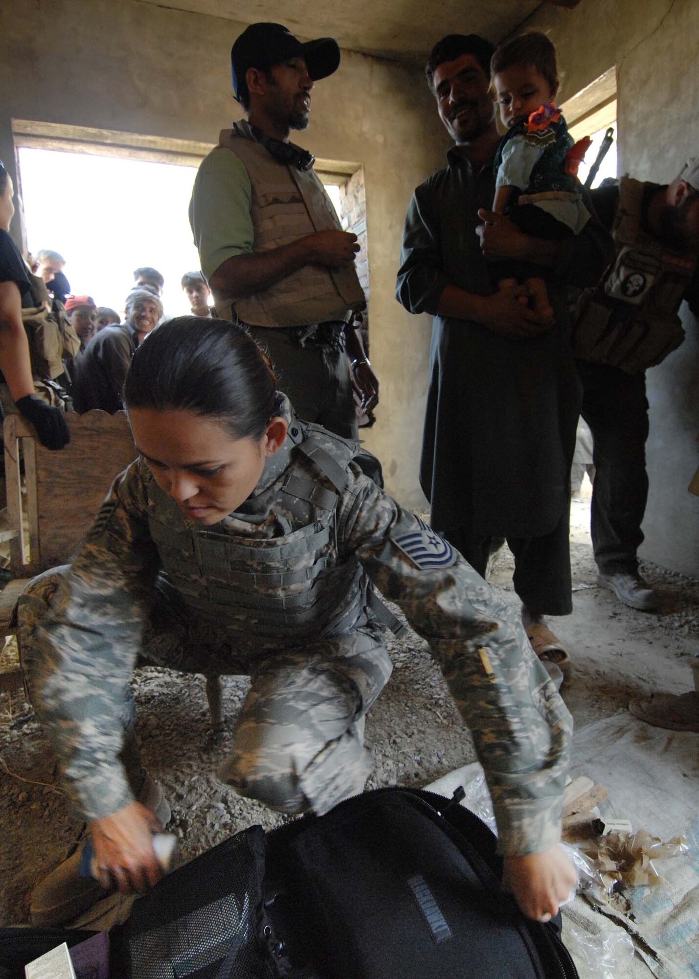 BAGRAM AIRFIELD, Afghanistan - Tech. Sgt. Joy Flumerfelt (left), an Air Force medical technician with the 455th Air Expeditionary Wing,  provides medical care to a small village outside of here Oct. 4, 2007.  (U.S. Air Force photo/Staff Sgt. Joshua T Jasper) (Released)