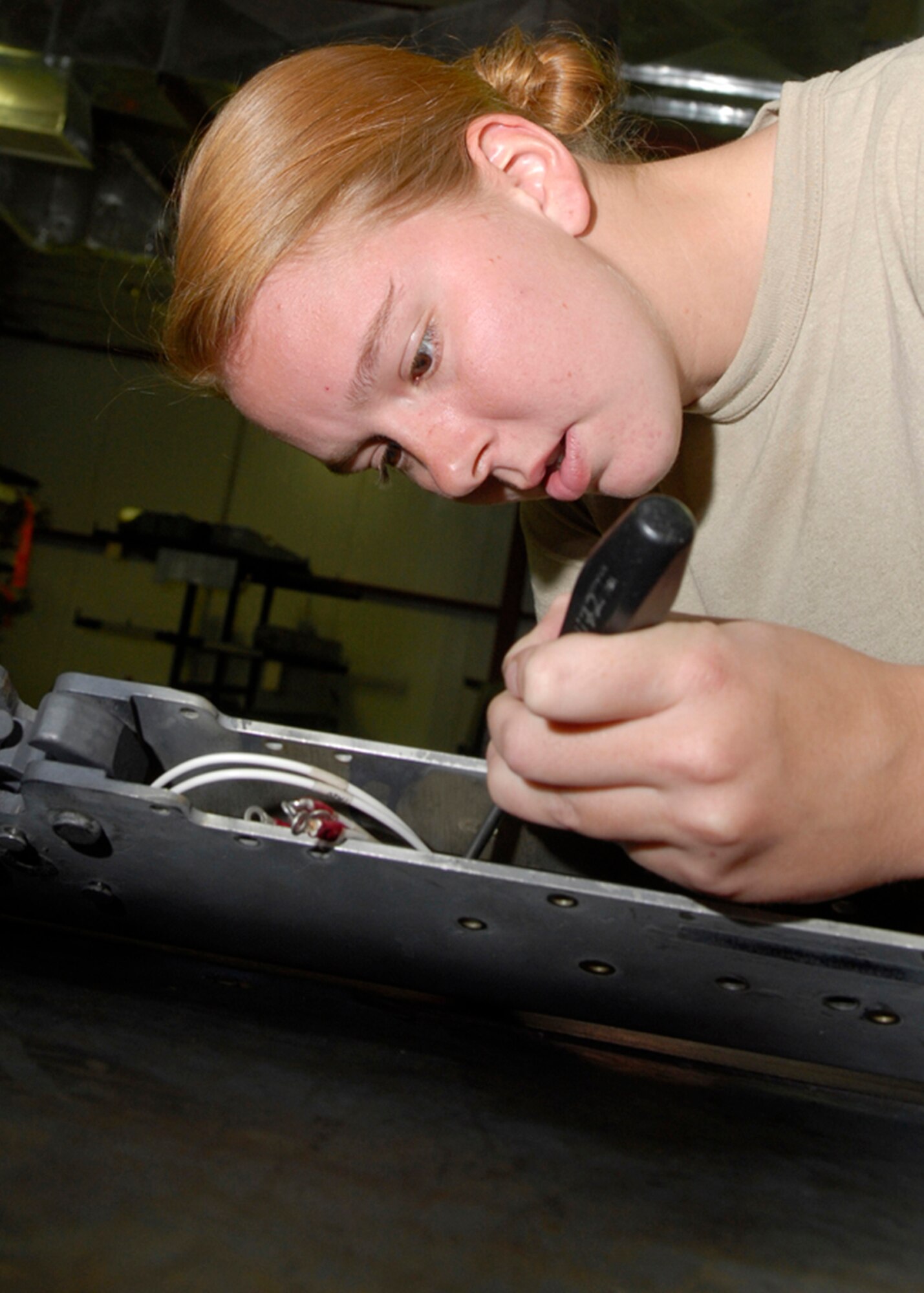 BALAD AIR BASE, Iraq -- Airman 1st Class Melissa Cunningham, 332nd Expeditionary Maintenance Squadron, replaces a damaged electrical connector to a Triple Ejector Rack-9A. The TER-9A carries various munitions that are used on the F-16 Fighting Falcon. Airman Cunningham is currently deployed from Spangdahlem Air Base, Germany. (U.S. Air Force photo/Staff Sgt. Joshua Garcia)