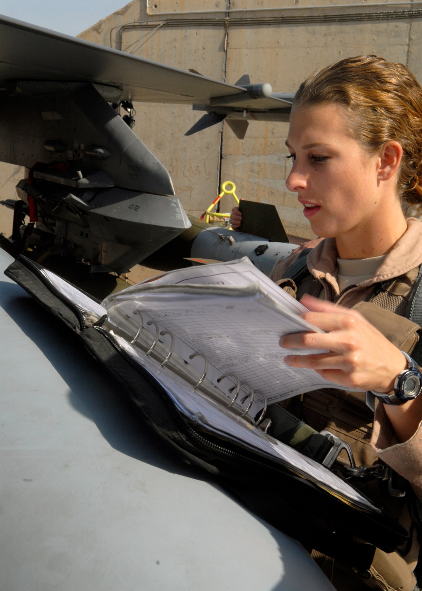 BALAD AIR BASE, Iraq -- Capt. Kerri Fulgham, 4th Expeditionary Fighter Squadron, goes over her checklist prior to her flight here, Oct. 23. Inspecting the aircraft prior to takeoff enhances communication between the pilot and maintenance personnel. Captain Fulgham is currently deployed from Hill Air Force Base, Utah. (U.S. Air Force photo/Staff Sgt. Joshua Garcia)