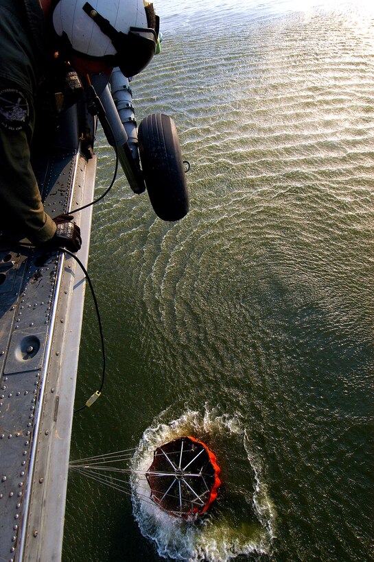 Navy Petty Officer 3rd Class Zach Sykora, attached to Helicopter Sea Combat Squadron 85, uses a winch to dunk a 420 gallon "Bambi Bucket" in a reservoir. 