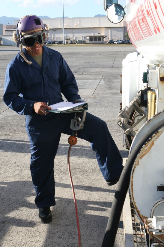 Sergeant Milton Gamez, base fuels noncommissioned officer, writes down the amounts and levels of fuels loaded into a vehicle for use on an aircraft, Wednesday. The fuels specialists fill vehicles on the flight line where their tanks feed purified fuel for use around the base.