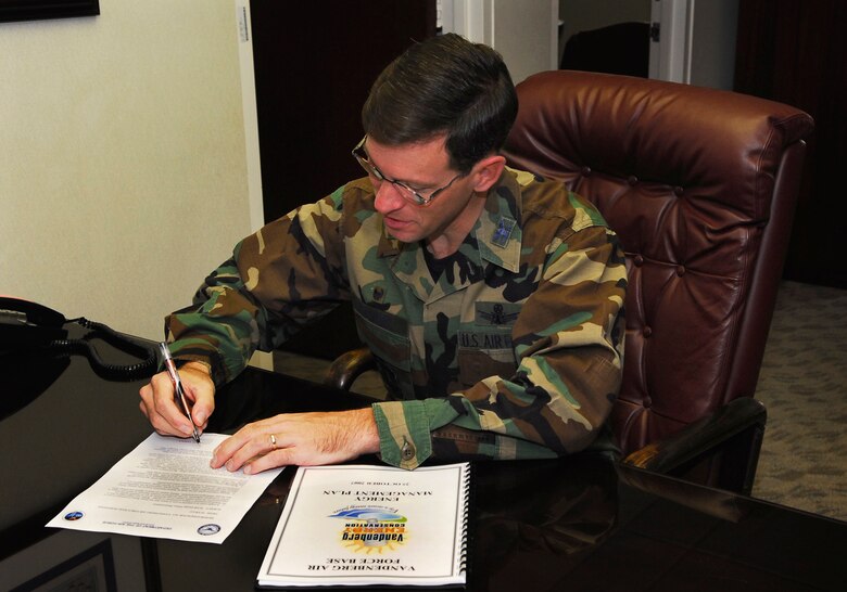 Col. Steve Tanous, 30th Space Wing commander, signs Vandenberg's energy conservation plan here on Oct. 25. The first-of-its-kind document contains the Wing’s strategic vision and goals for energy and water conservation as well as detailed tactical plans that tell people at all levels of the base what they can do to conserve. 