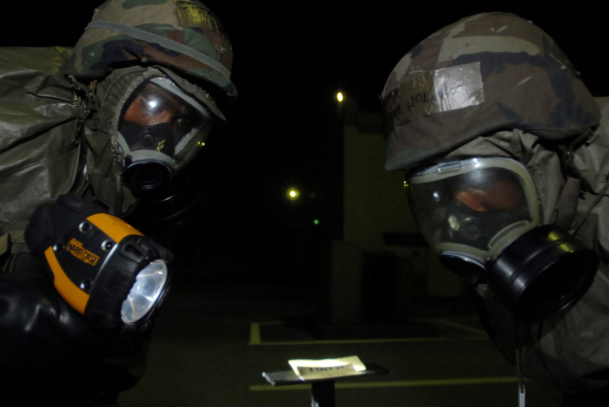 Staff Sergeant Jeffrey Williams, 18th Component Maintainence  Squadron, shines his flashlight so Senior Airman Ransom Holland, 18th CMS, can inspect the M-8 chemical detection paper during a sweep Oct. 25, 2007. The Airmen were supporting training missions based on real-world scenarios as part of Local Operational Readiness Exercise Beverly High 08-1. (U.S. Air Force photo/Senior Airman Darnell T. Cannady) 