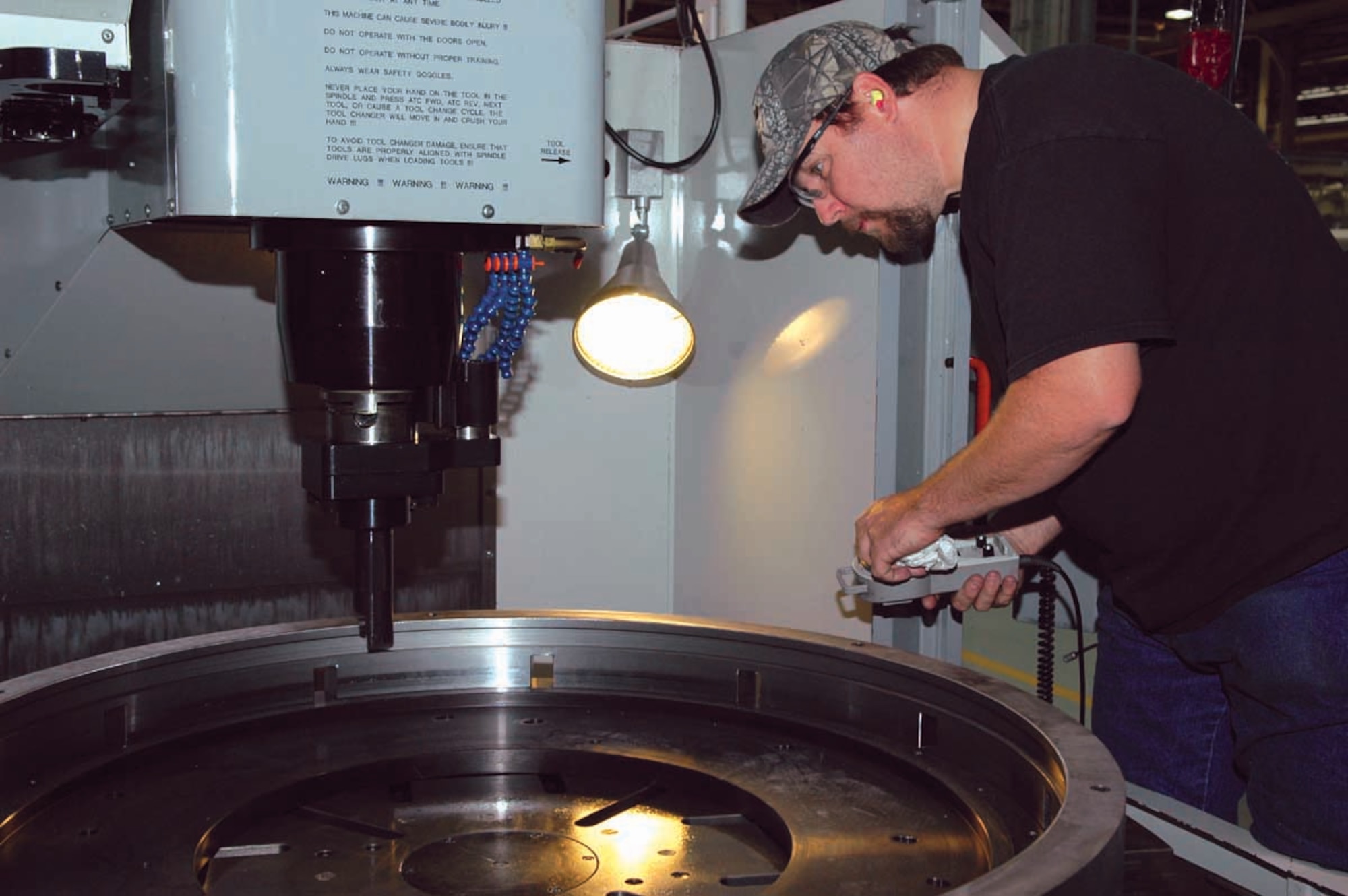 John Gee, a toolmaker with the 547th Propulsion Maintenance Squadron, prepares a vertical turning center machine to bore the inside diameter on a fixture that holds aircraft parts. (Air Force photo by Ron Mullan)