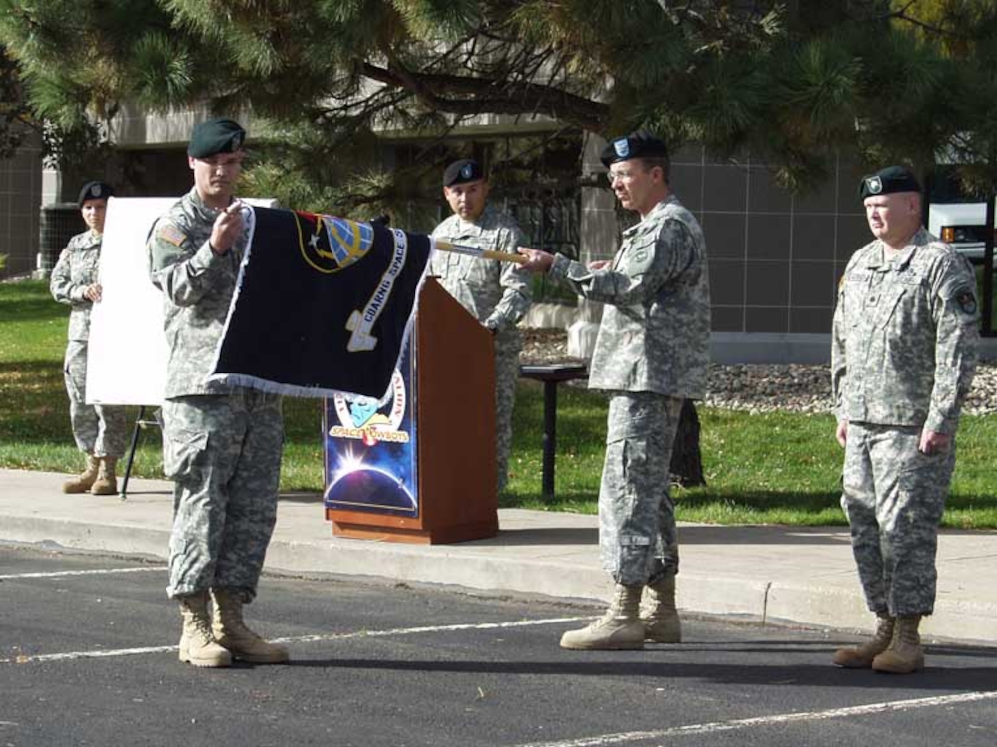 Command Sgt. Maj. Timothy Ward, 117th Space Battalion, unfurls colors flown millions of miles in space with the assistance of Col. Robert Balster, commander, 89th Troop Command, Colorado National Guard. The flag of the newly designated 117th Space Bn. was flown on shuttle mission, STS-117 Atlantis, and was presented to the unit by Army Astronaut (retired) Col. Patrick Forrester. U.S. Army photo by Sharon Hartman)