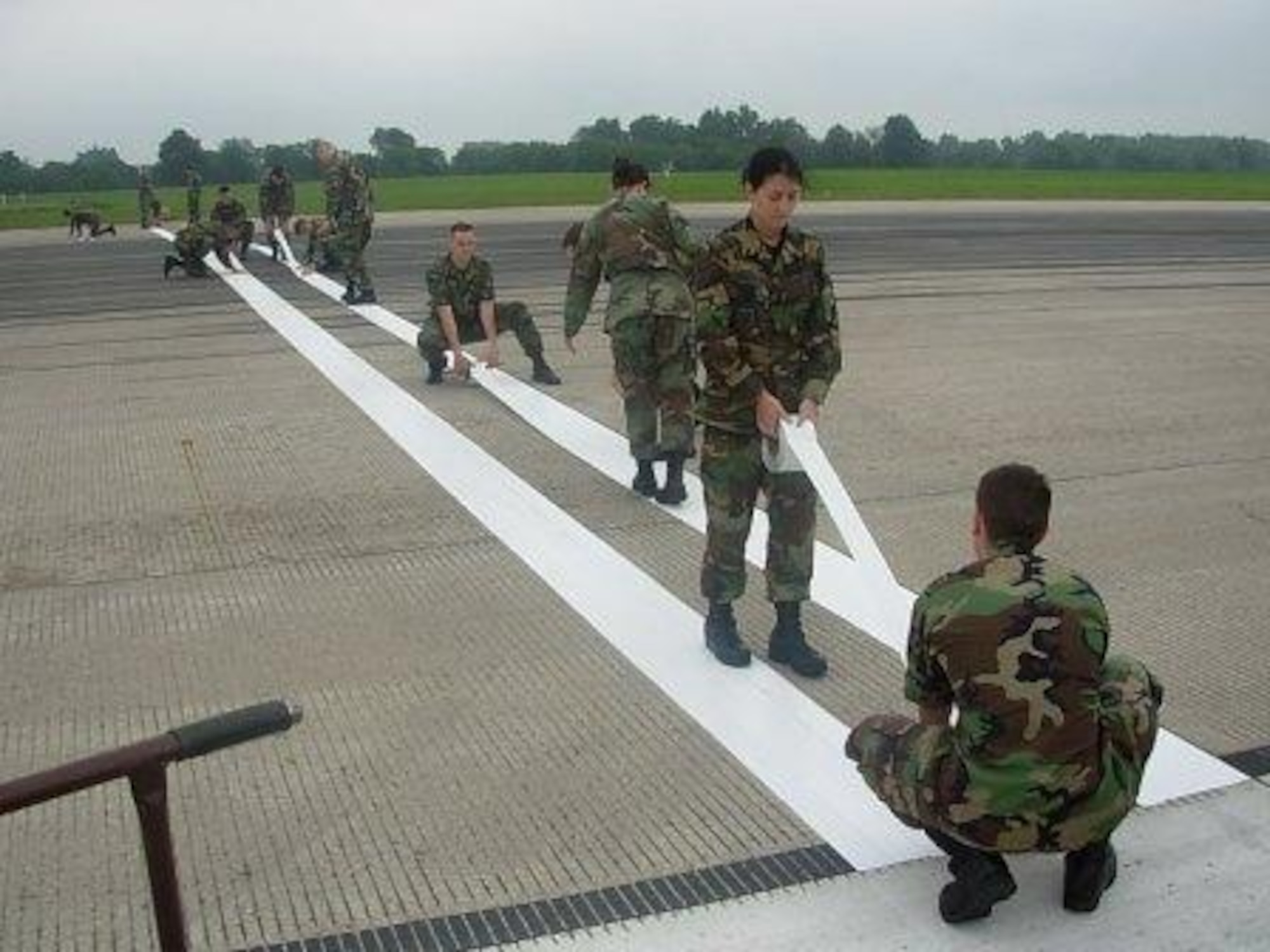 Airman from the 823rd Red Horse Squadron lay aircraft markings down on the runway at Whitman Air Force Base, MO. (U.S. Navy photo by Lieutenent JG Meskill)
