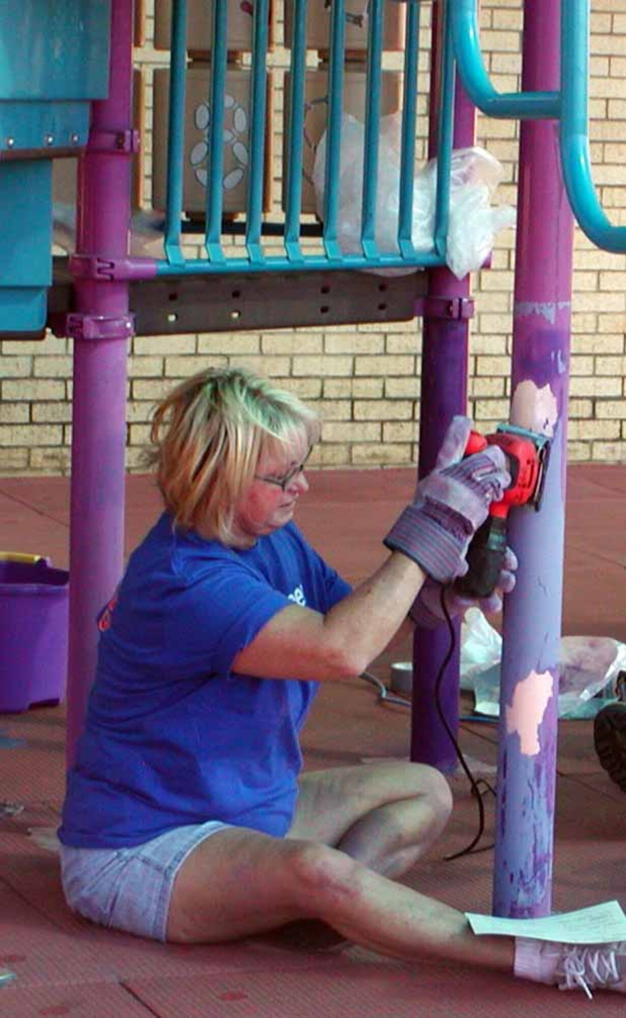 Sandy Meyer, 72nd Communications Squadron, works to refinish the Tinker Youth Center’s gym set. (Air Force photo by Debbie Tapparo)