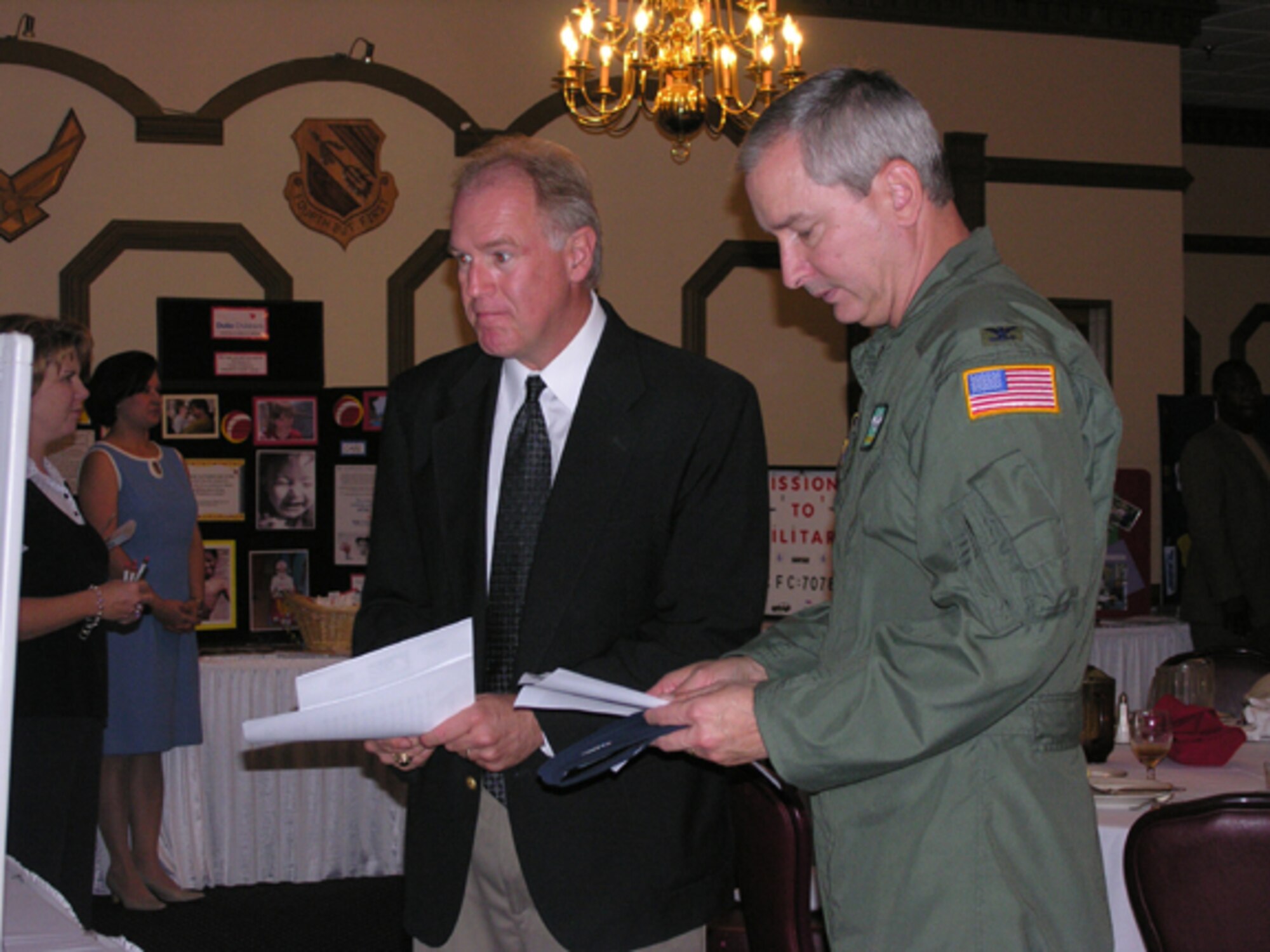 SEYMOUR JOHNSON AIR FORCE BASE, N.C.--The  Combined Federal Campaign began the 2007 season with a luncheon at the NCO Club here on Oct. 22.  Members of the 4th Fighter Wing and 916th Air Refueling Wing were able to talk to some of the CFC charitable organizations involved.  Col. Fritz Linsenmeyer, 916th ARW commander, looks over a brochure that was given to him by Mr. Richard Lambert, 4th Figther Wing Mission Support Squadron Community Readiness Consultant.
