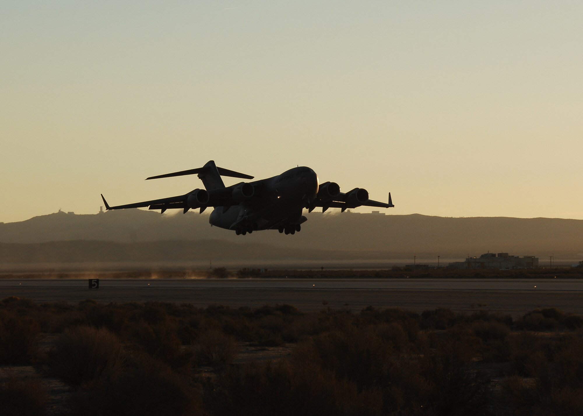 A C-17 Globemaster III takes off from Edwards Air Force Base, Calif., on Oct. 19. The early-morning flight marked the first flight of the C-17 using a Fischer-Tropsch synthetic fuel blend in one of its engines. All four engines ran the fuel blend in a test flight here Oct. 22.(Photo by Jim Shryne)