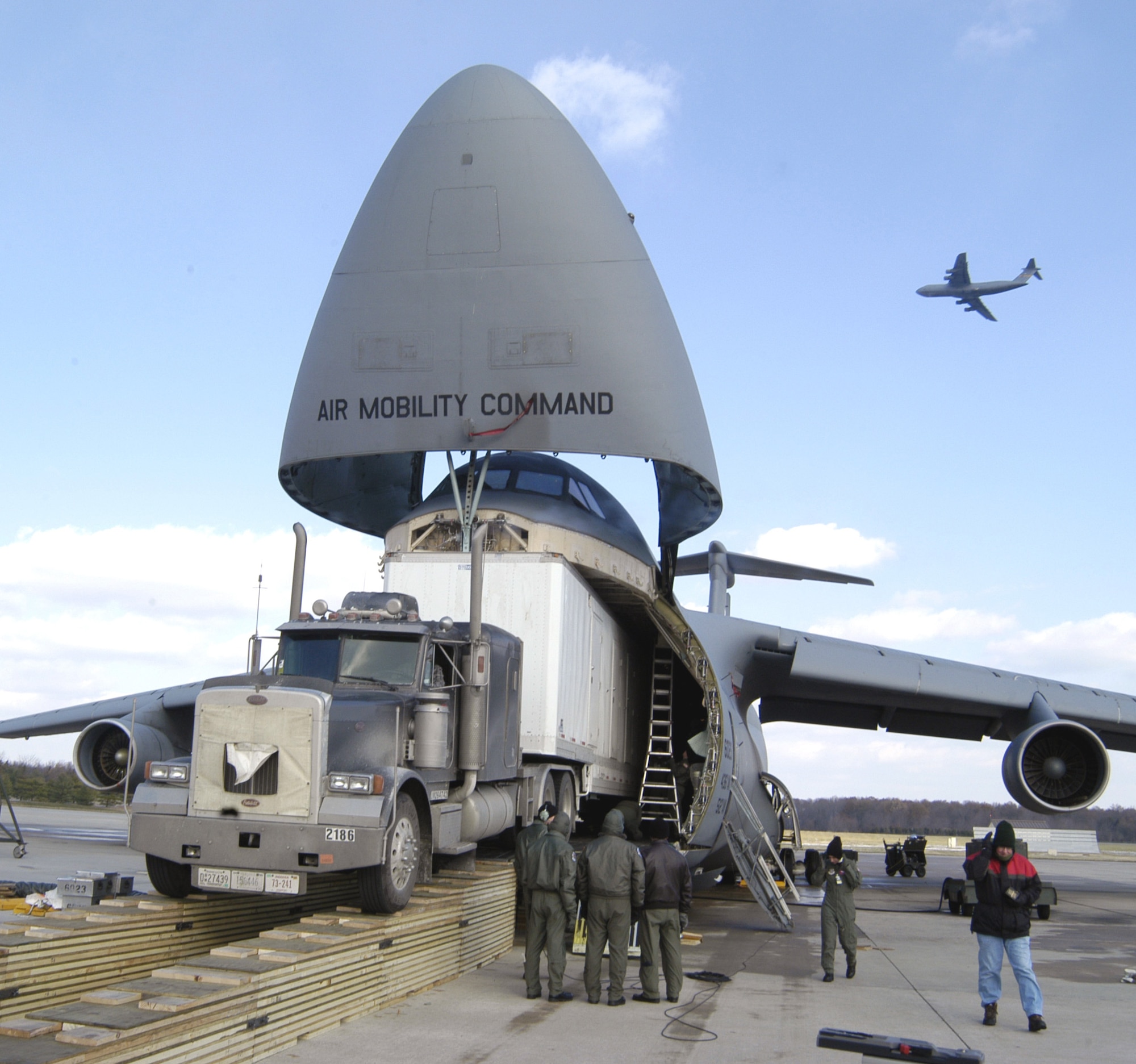 Members of the 436th Airlift Wing work together with Army contractors here to load the Aviation Combined Arms Tactical Trainer, an Army helicopter training simulator, onto a C-5 Galaxy. (U.S. Air Force photo/Staff Sgt. James Wilkinson)                       