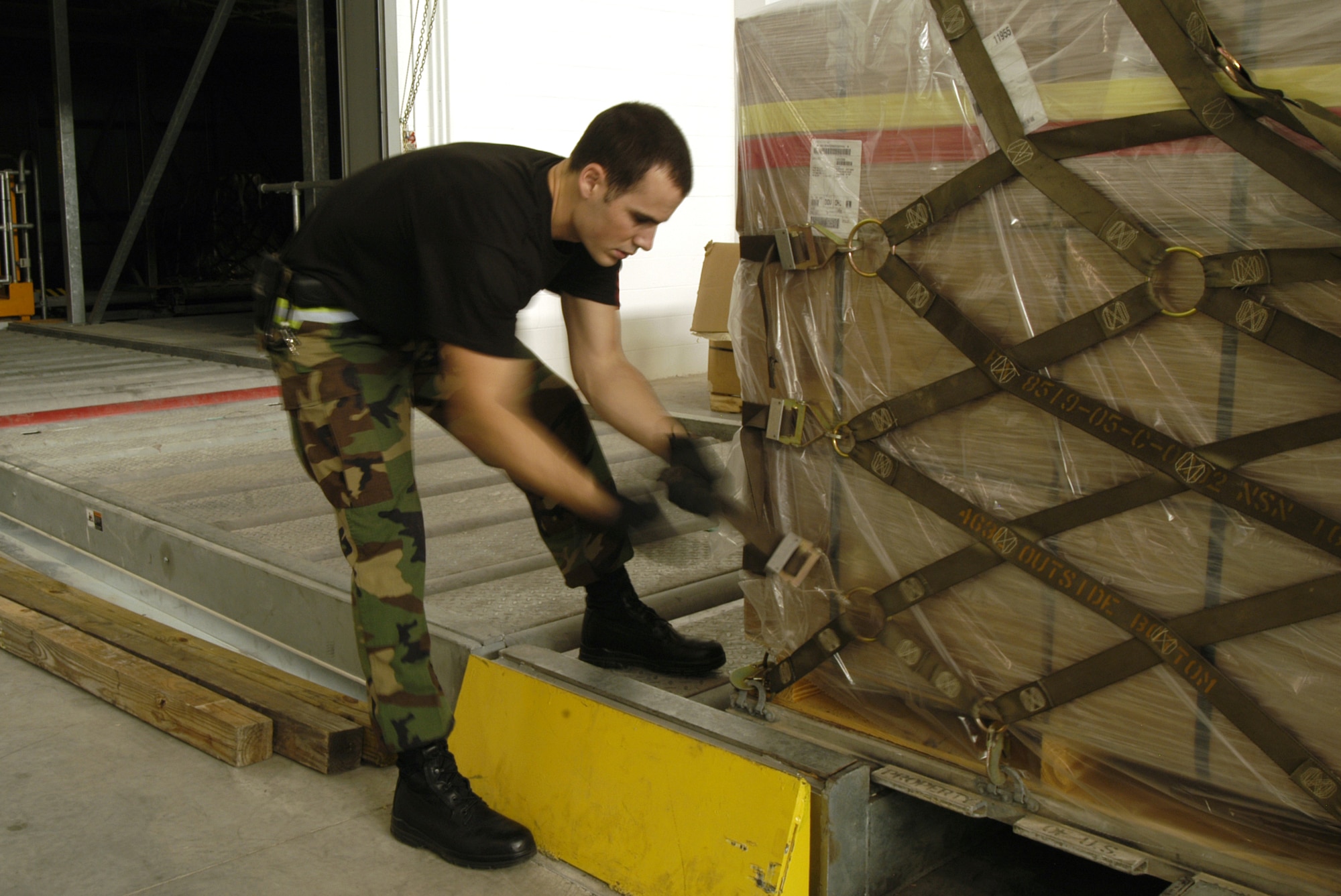 Airman 1st Class Nicholas Cross, 436th Aerial Port Squadron cargo processor and Chico, Calif., native, palitizes a piece of cargo at Dover's new Air Freight Terminal. Airman Cross, a 1.5 year Air Force veteran, takes peices of equipment and builds palets which are then loaded on to C-5 Galaxy and C-17 Globemaster aircraft and flown to Iraq and Afghanistan. Their the equipment is unloaded and used by deployed Soldiers, Marines and Airmen. (U.S. Air Force photo/Senior Airman James Bolinger)