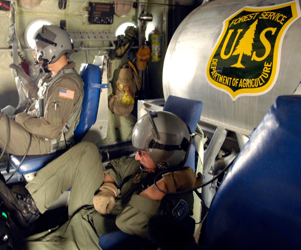 Master Sgt. Tom Freeman (left) and Tech. Sgt. Lamont Wood prepare to deploy 3,000 gallons of fire retardant Oct. 24 over the Poomacha fire in North San Diego County, Calif. The C-130 Hercules and crew are assigned to the 302nd Airlift Wing from Peterson Air Force Base, Colo. The aircraft launched from Channel Islands Air National Guard Station, Calif. Air Force Reserve Command officials are participating in the Southern California firefighting effort. (U.S. Air Force photo/Tech. Sgt. Roy. A. Santana)
