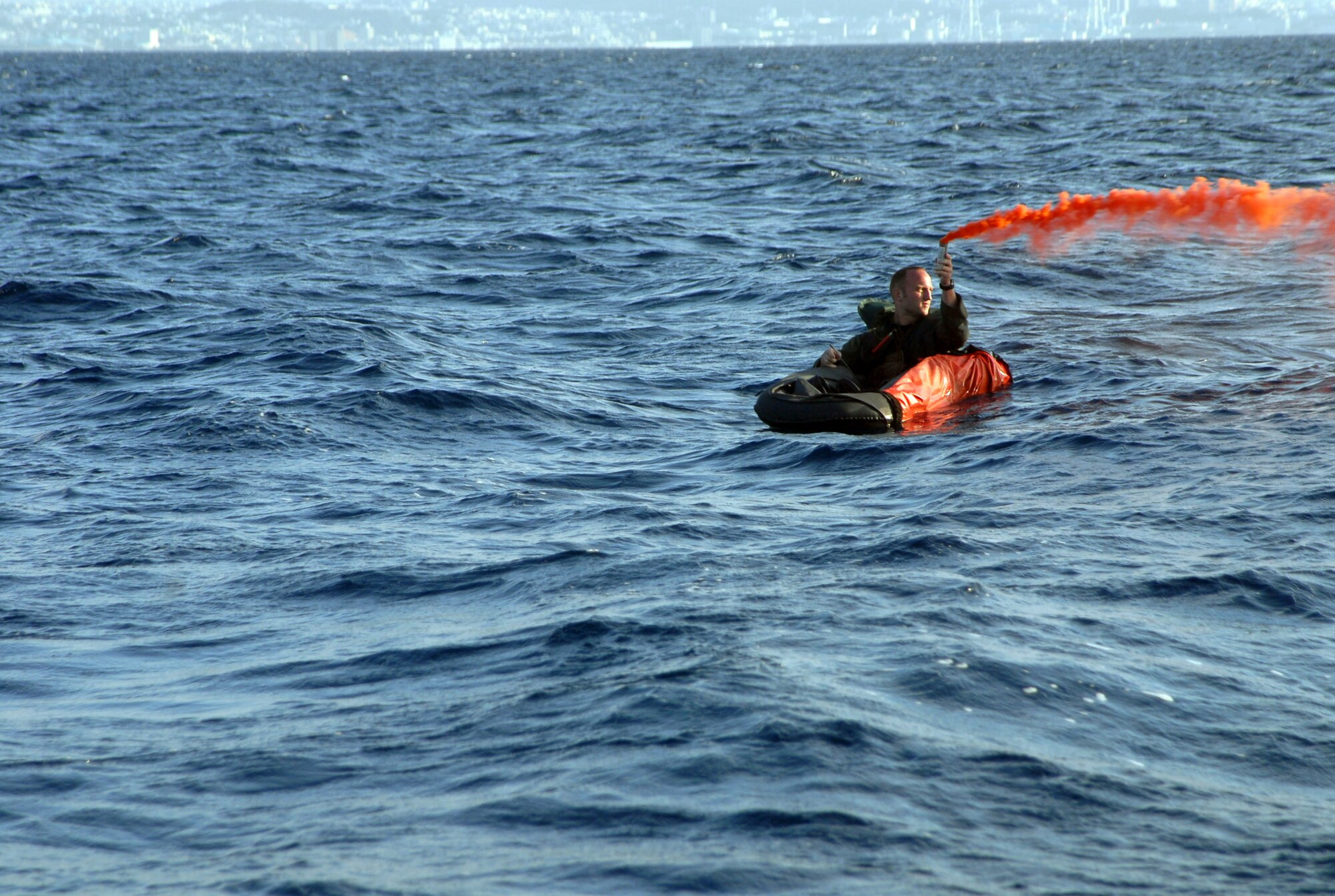 Capt. Derek Flynn pops smoke in order to attract rescue efforts Oct. 24 in the waters off the coast of Okinawa. Captain Flynn of the 67th Fighter Squadron was placed in the water as part of a survival, evasion, resistance and escape exercise at Kadena Air Base, Japan. (U.S. Air Force photo/Staff Sgt. Christopher Marasky) 