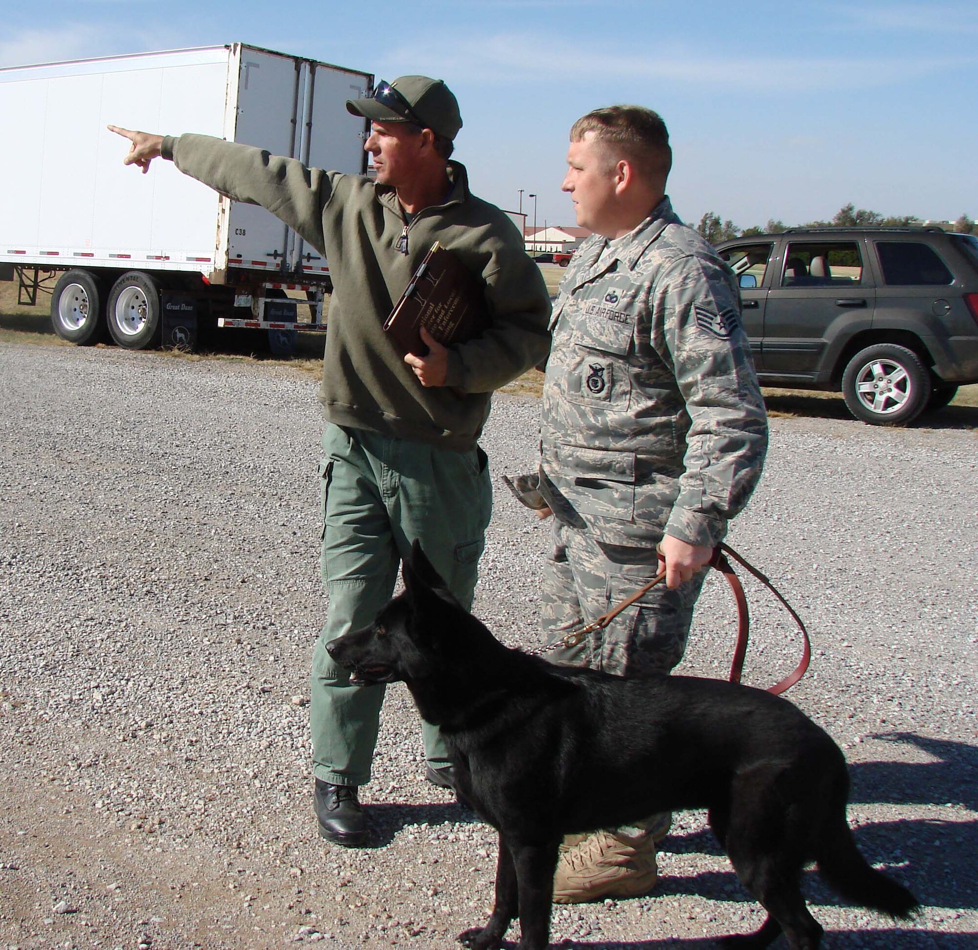 National Police Canine Association instructor Paul Koinig briefs Staff Sgt. Jonathan Hein of the 71st Security Forces Squadron, on a search for explosive materials with military working dog Cinni. (U.S. Air Force photo by 2nd Lt. Agneta Murnan)