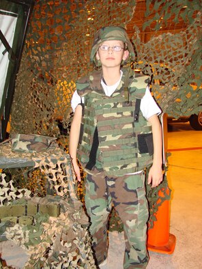Patrick W. Browne, 12, tries on a flak jacket and helmet at "Camp Liberty" at Vance Air Force Base during Operation Kids Oct 19. The program offers children of military parents a better understanding of the deployment process through various hands-on activites such as trying on military clothing and equipment. (U.S. Air Force photo by 2nd Lt. Agneta Murnan) 
