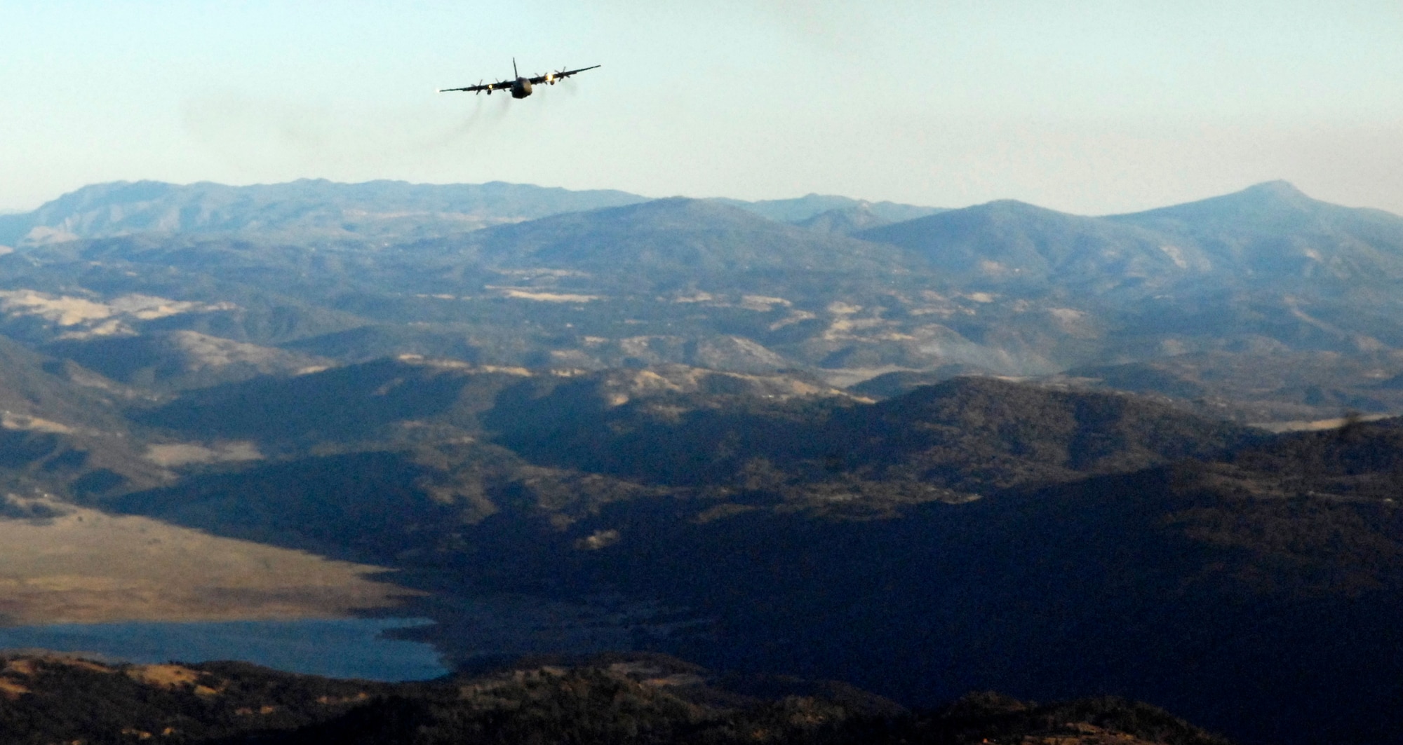 A C-130 Hercules launched from Channel Islands Air National Guard Station in  California flies over San Diego County Oct. 24. Air Force Reserve Command Airmen assigned to the 302nd Airlift Wing from Peterson Air Force Base, Colo., are participating in the Southern California firefighting effort. Air Force Reserve Command sent two of its designated firefighting C-130H3 aircraft to help battle the raging wildfires in Southern California. (U.S. Air Force photo/Tech. Sgt. Roy. A. Santana)
