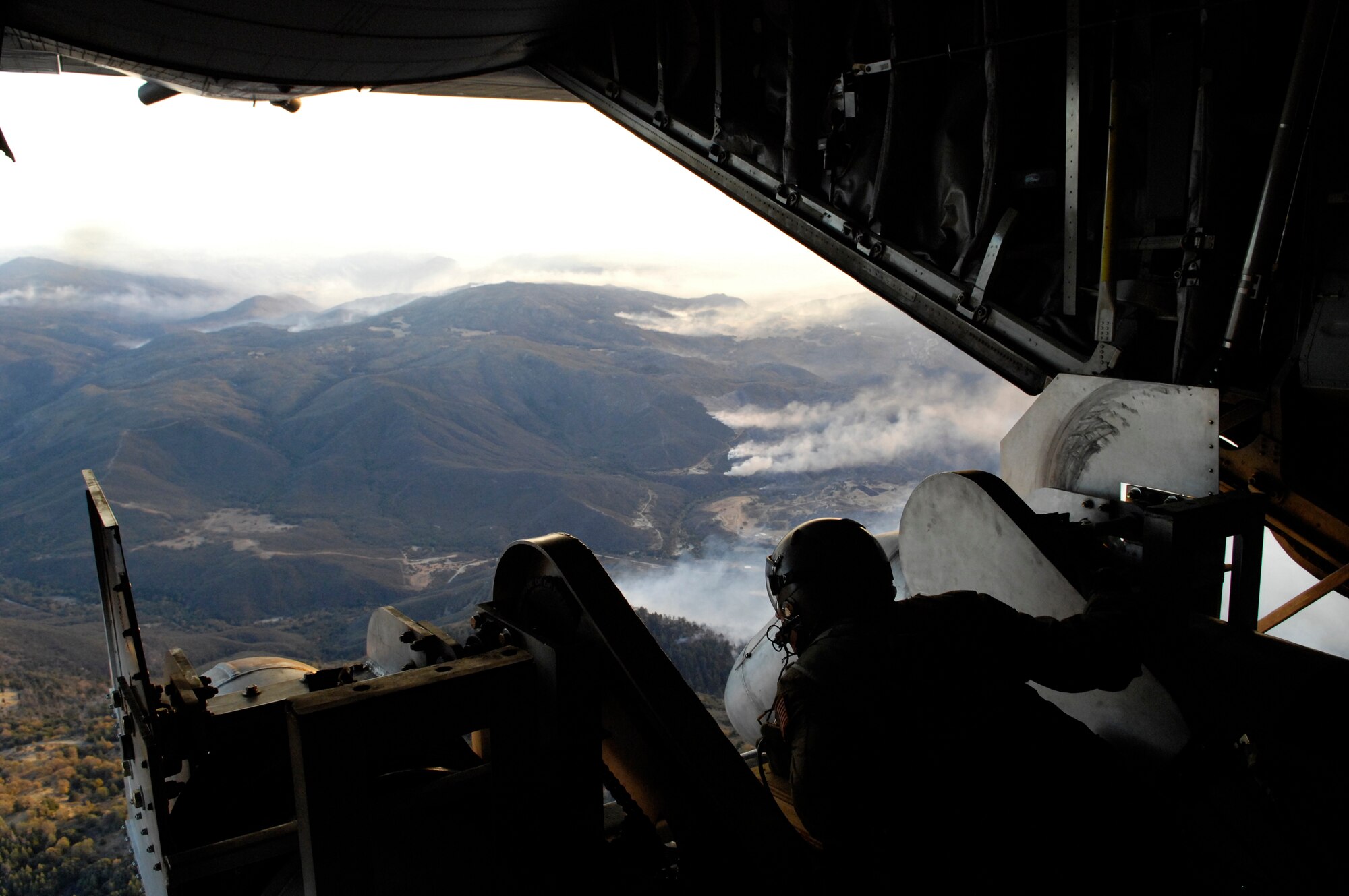 Tech. Sgt. Lamont Wood checks the positioning of the nozzles prior to deploying 3,000 gallons of fire retardant over the Poomacha fire Oct. 24 in North San Diego County, Calif. The C-130 Hercules and crew are assigned to the 302nd Airlift Wing from Peterson Air Force Base, Colo. The aircraft launched from Channel Islands Air National Guard Station, Calif. Air Force Reserve Command officials sent two of its designated firefighting C-130H3 aircraft to help battle the raging wildfires in Southern California. (U.S. Air Force photo/Tech. Sgt. Roy. A. Santana) 
