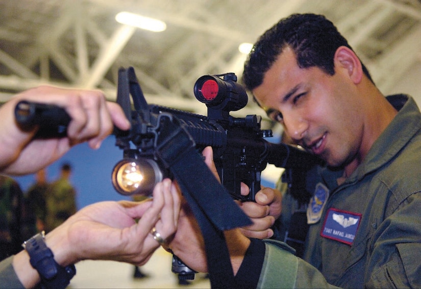 Tech. Sgt. Rafael Jauregui, Jr. peers through the scope sights of an M-4 during a hands-on weapons orientation, during the Ravens security demonstration inside hangar four on Sept. 25. The Raven Team's mission is to provide security for all special air missions carrying the President, Vice President and other senior government leaders during their official travel. Sergeant Jauregui is assigned to the 1st Airlift Squadron as a special missions flight attendant. (US Air Force/A1C Renae Kleckner)