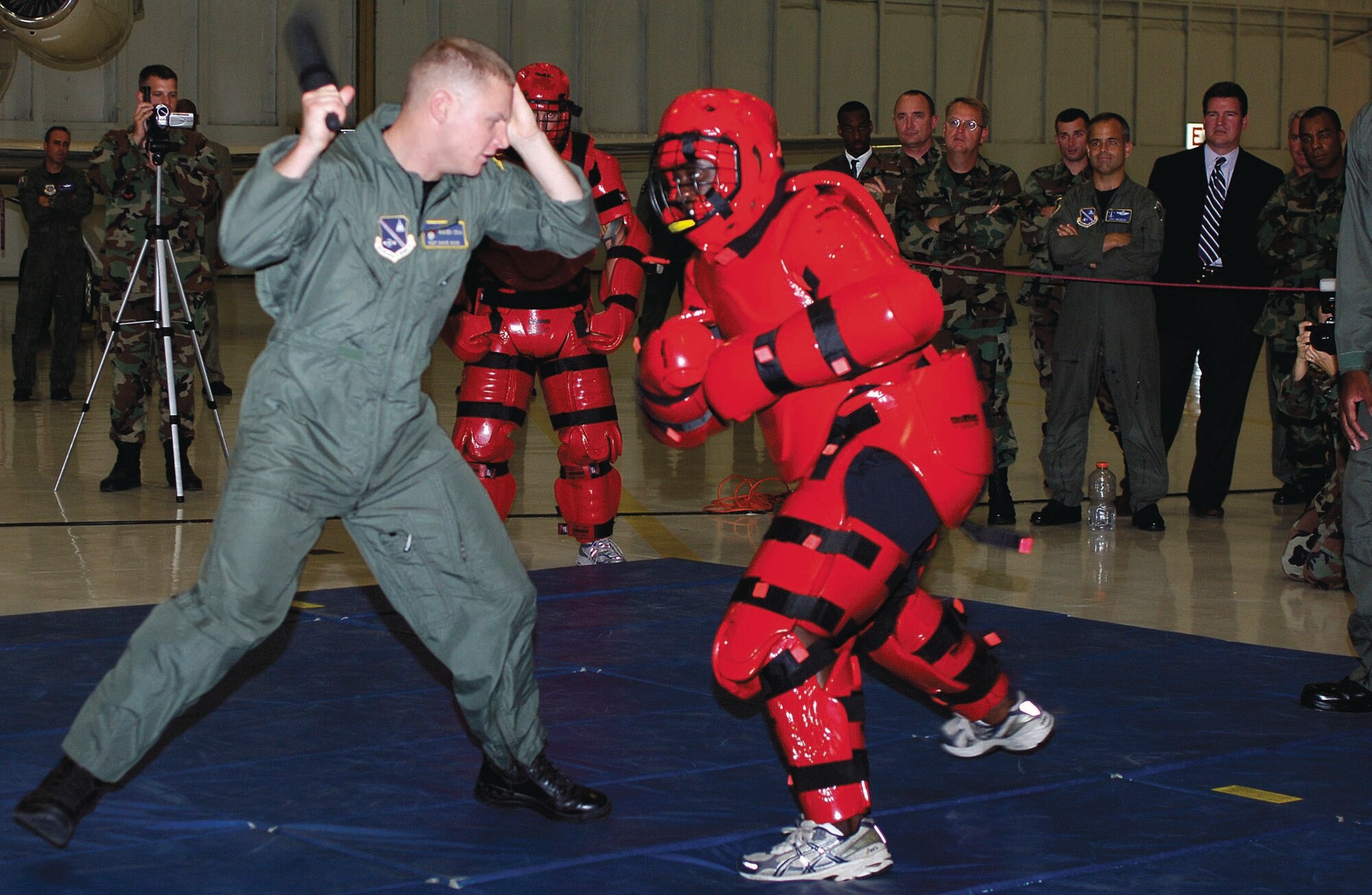 Staff Sgt. David Wood and Staff Sgt Martez Blair, 316th Security Forces Squadron Ravens, simulate a physical disagreement during a demonstration inside hangar four on Sept. 25. The Raven Team's mission is to provide security for all special air missions carrying the President, Vice President and other senior government leaders during their official travel. (US Air Force/SSgt Suzanne Day)