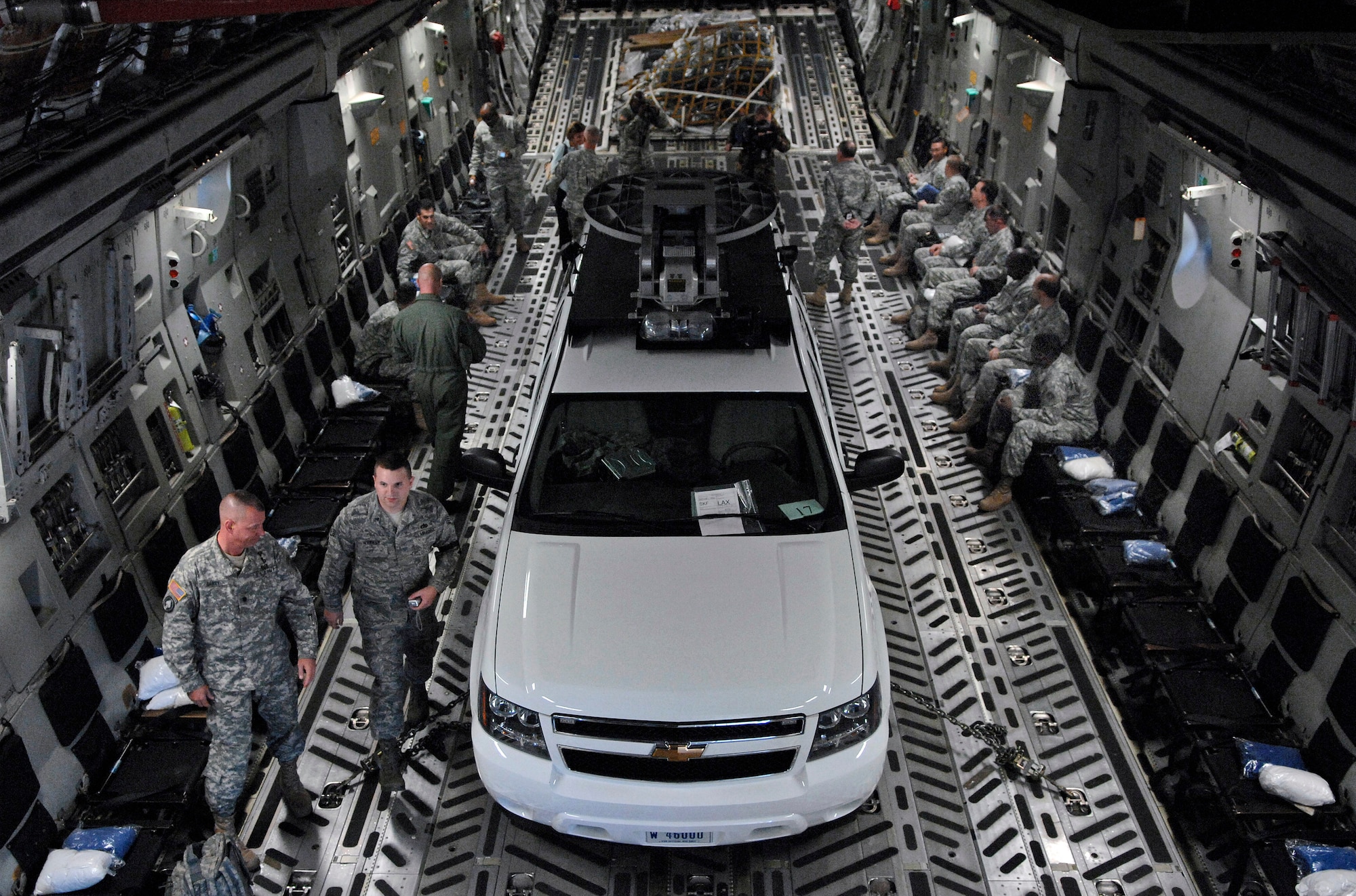 Army Soldiers prepare for the flight to California as Airmen with the 97th Operations Support Squadron and the 58th Airlift Squadron make final preparations after loading an Army emergency response vehicle onto a C-17 Globemaster III Oct. 24 in San Antonio. The Soldiers and emergency response vehicle are being airlifted to California to help support personnel battling the wildfires. Members of the 97th OSS and the 58th AS, as well as the C-17 are from Altus Air Force Base, Okla. The Army Soldiers and equipment are from U.S. Army North based at Fort Sam Houston in San Antonio. (U.S. Air Force photo/Tech. Sgt. Larry A. Simmons)