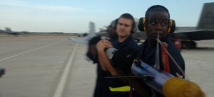LANGLEY AIR FORCE BASE, Va. -- Weapons Loaders, Airman 1st Class Lamont Williams of the 27th Aircraft Maintenance Unit, Staff Sgt. Neal Rothenbach of the 192nd Fighter Wing, and Senior Airman Kevin Haggans of the 27th AMU carry a training missile as part of a weapons load competition on the flight line Oct. 23.  (U.S. Air Force photo/Senior Airman Christopher L. Ingersoll)