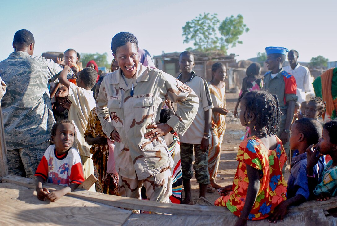 Master Sgt. Shani Prewitt laughs with the children of Nagad, Djibouti, following a performance in the village Oct. 23. Sergeant Prewitt is a vocalist with the U.S. Central Command Air Forces' Expeditionary Band Live Round. The band is touring Djibouti to perform a series of morale and community outreach concerts. (U.S. Army photo/Sgt. Charles Siler) 
