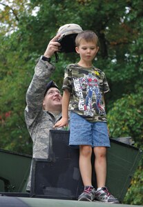 Staff Sgt. Christopher West, 316th Security Forces Squadron, places a Kevlar helmet on James O'Leary, son of Capt. Steven O'Leary, Air Force Office of Analysis, Assessments and Lessons Learned, during Truck Day at Corkran Preschool, Temple Hills, Md. Oct. 5. (US Air Force/A1C Renae Kleckner)