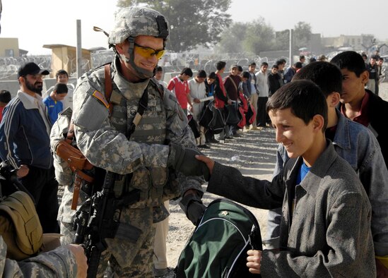 Master Sgt. William Whitt passes out soccer balls and gear to local children from the Kabul Youth Soccer League Oct. 22 outside the gate at Kabul International Airport, Afghanistan. The equipment was donated by businessmen and supporters from Tennessee, Georgia and California. Sergeant Whitt's wife, Lea-Ellen Whitt, was instrumental in the effort in Tennessee. (U.S. Air Force photo/Staff Sgt. Brian Ferguson)