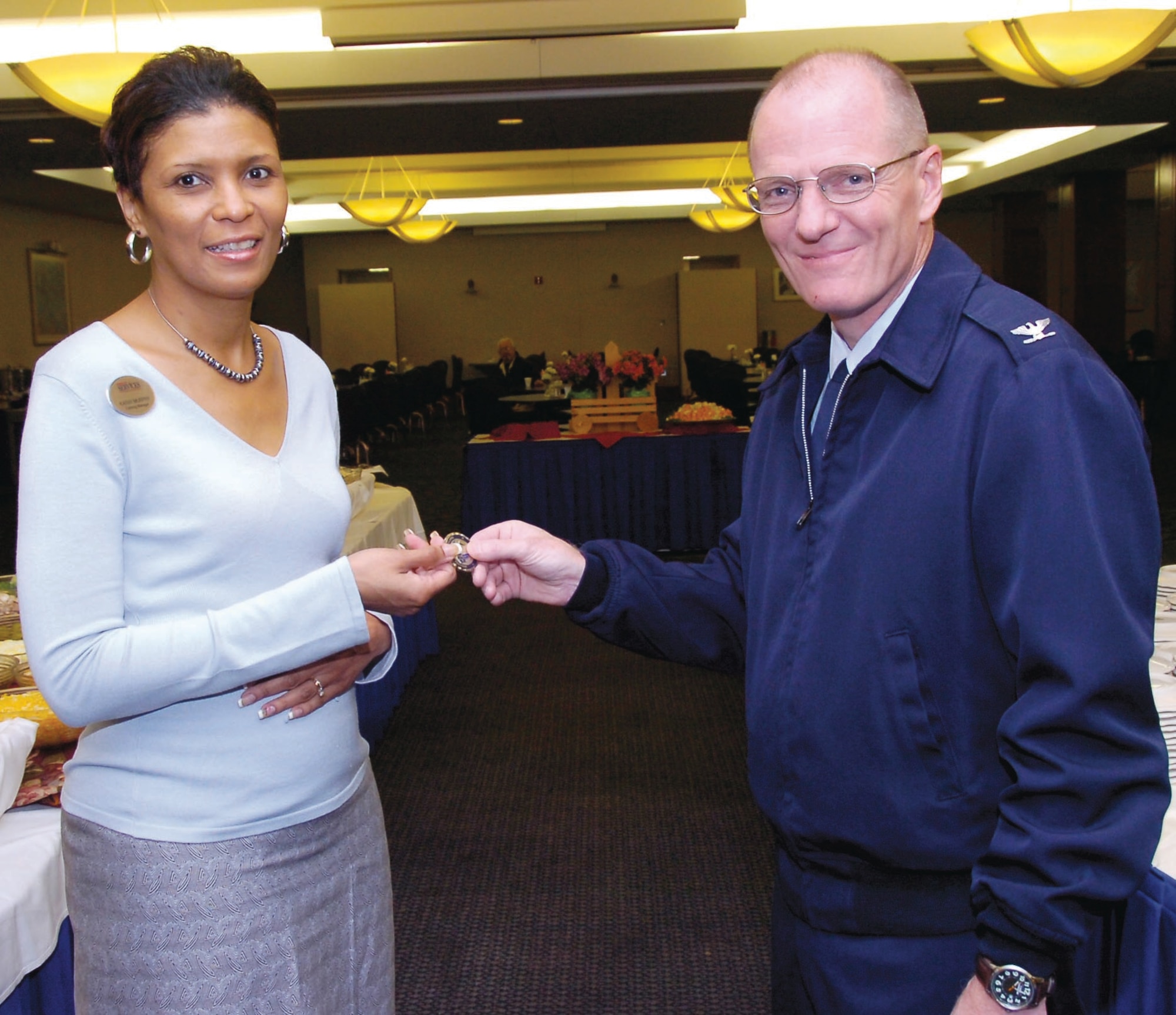 Kathy Murphy, The Club at Andrews Catering Manager, gladly accepts the 315th Wing Commander's Coin. Kathy has exhibited superior leadership and teamwork since she has been here. September was extremely busy with more than 70 events including serving more than 500 people from the 303rd Bomber Group. She manages as well as sets a good example by serving and bussing tables. (US Air Force/Bobby Jones)