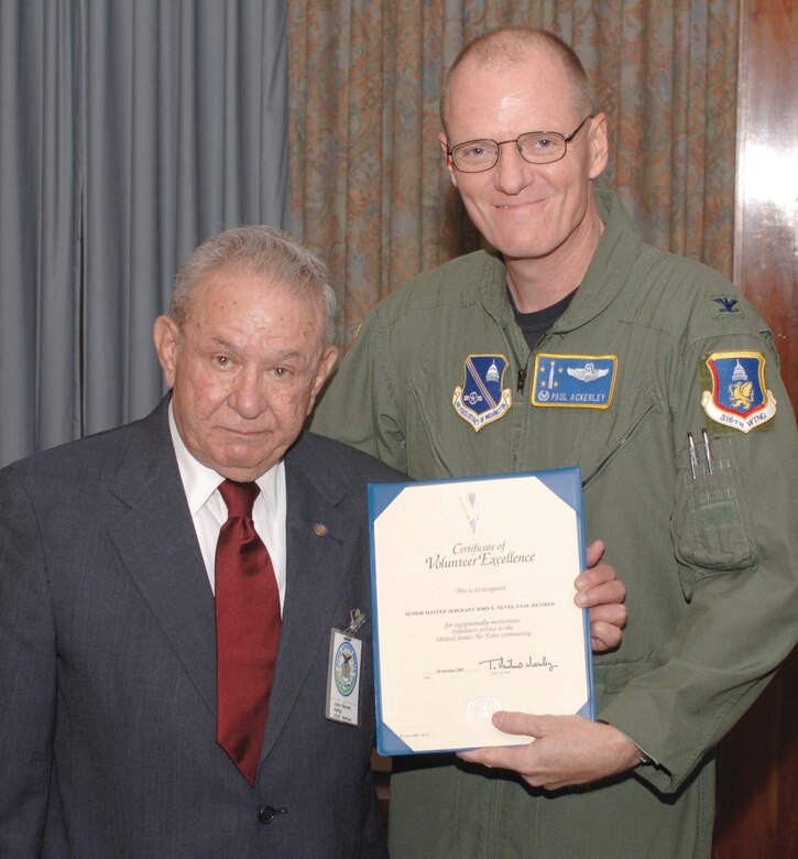 Col. Paul R. Ackerley, 316th Wing commander, presents Mr. John Neves, 316th Wing Retiree Activities Office director, with a certificate of volunteer excellence for his time as the RAO director, during the Retiree Appreciation Day luncheon Oct. 20. (US Air Force/TSgt Jason Edwards)