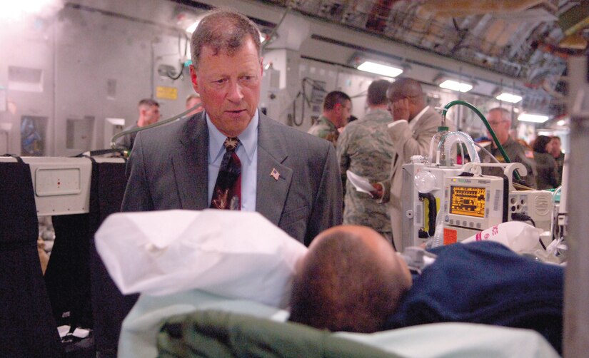 Ronald A. Winter, deputy assistant Secretary of the Air Force for Manpower and Reserve Affairs, speaks with an injured servicemember on an air medical evacuation flight that returned from overseas Oct. 19. (US Air Force/TSgt Christopher Matthews)