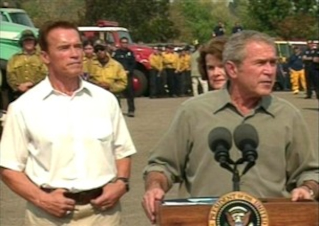 California Gov. Arnold Schwarzenegger looks on as President Bush answers questions from a reporter following a tour of the areas affected by wildfires, Oct. 25, 2007. 