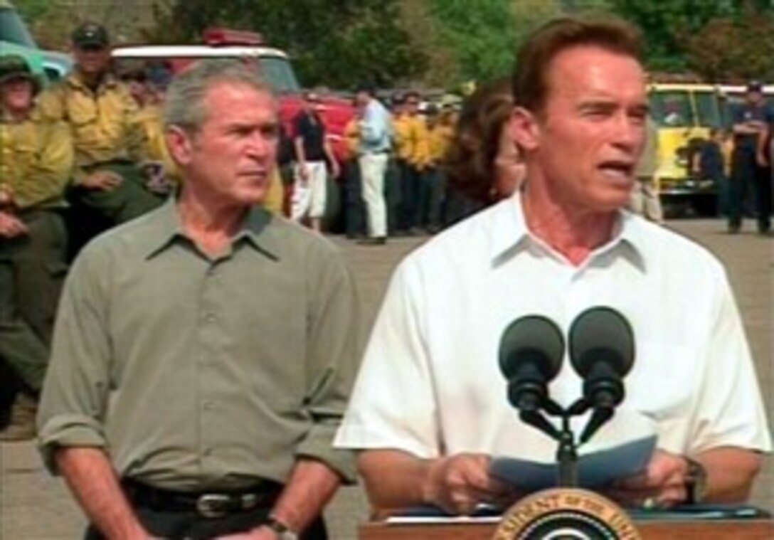 President Bush looks on as California Gov. Arnold Schwarzenegger speaks to reporters following a tour of the areas affected by wildfires, Oct. 25, 2007. 