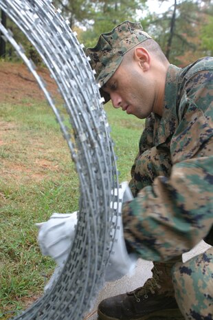 BLACKSTONE, Va. (Oct 29, 2007) - Cpl. Ervin Hernandez, administrative clerk, 24th Marine Expeditionary Unit, lays wire around the command element's Forward Operating Base during the Realistic Urban Training operation here.  RUT is an exercise designed by II Marine Expeditionary Force's Special Operations Training Group, and is intended to place the MEU in a simulated urban fighting environment other than training facilities found on a military installation.  The operation runs from Oct. 29 through November 12th.